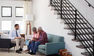 An agent from Premier Choice Insurance helping a Mesa homeowner review their policy to lower premiums — find out how to save on homeowners insurance and request your personalized coverage plan today.